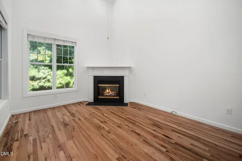 a living room with a fireplace and a floor to ceiling window