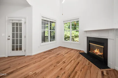 a view of empty room with wooden floor and fireplace