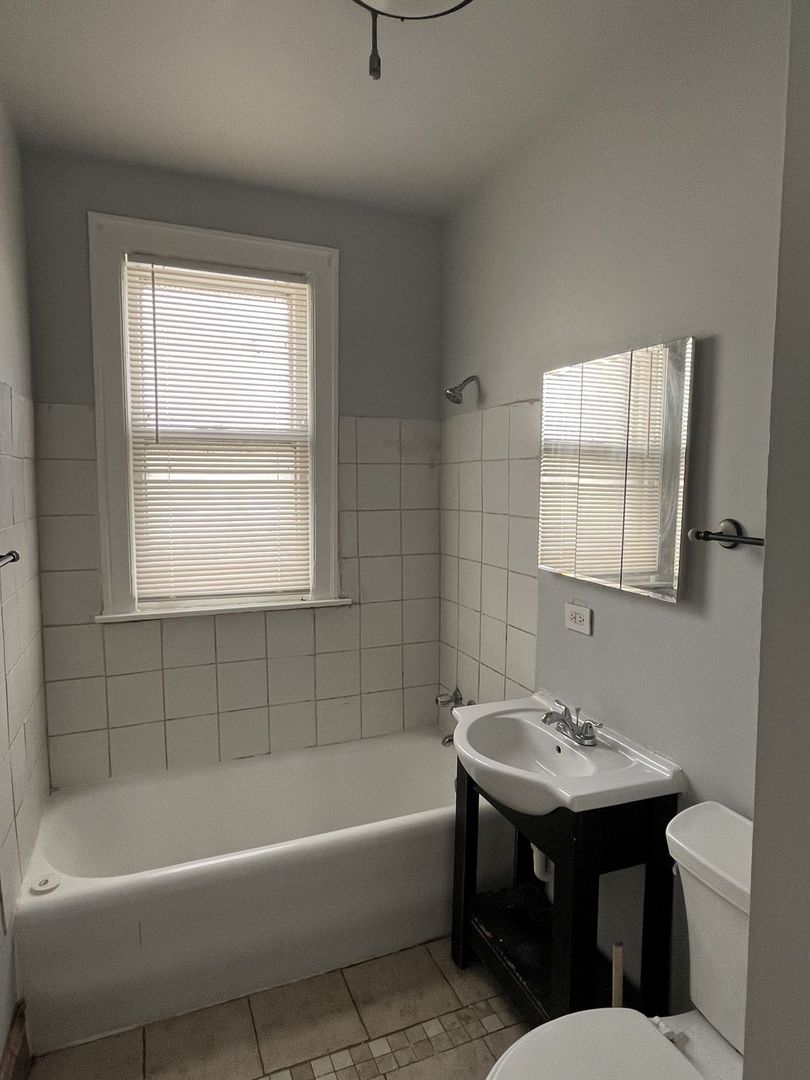 8019 South Vernon Avenue, Unit 2 Chicago, IL 60619 - Photo 11 of 13 a bathroom with a sink bathtub and a toilet