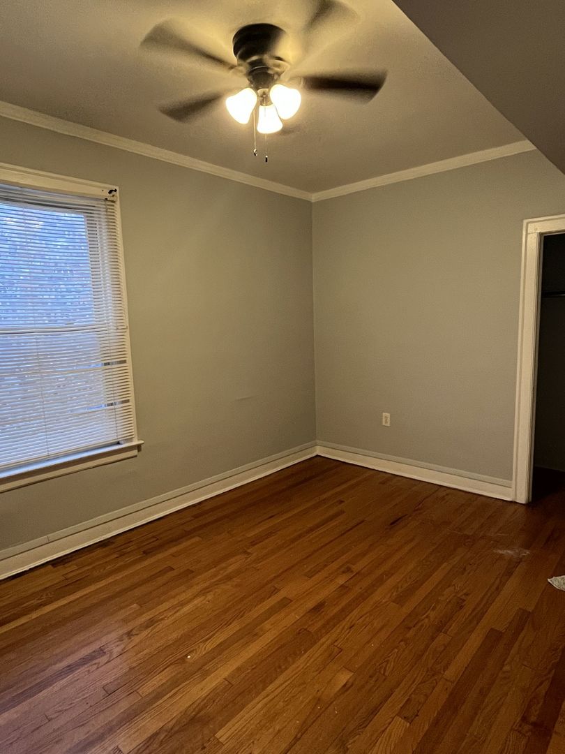 8019 South Vernon Avenue, Unit 2 Chicago, IL 60619 - Photo 10 of 13 a view of an empty room with wooden floor and a window