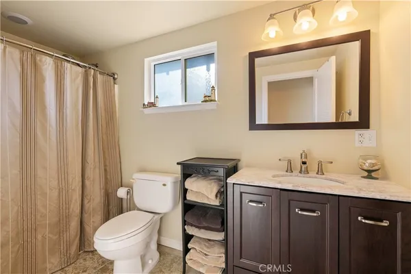 a bathroom with a toilet sink vanity and mirror