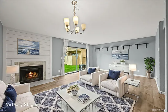 a living room with furniture a chandelier and a fireplace