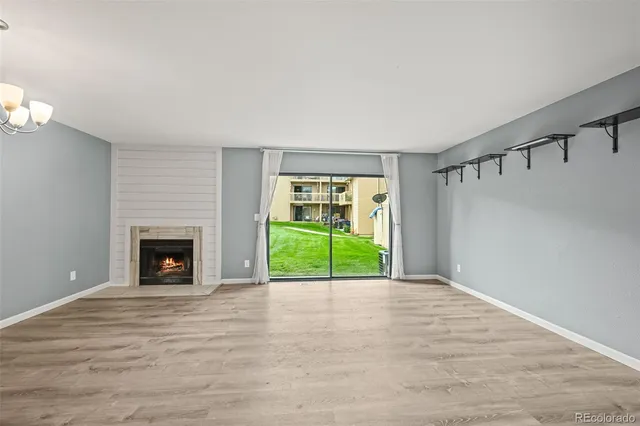 a view of an empty room with a fireplace and a window