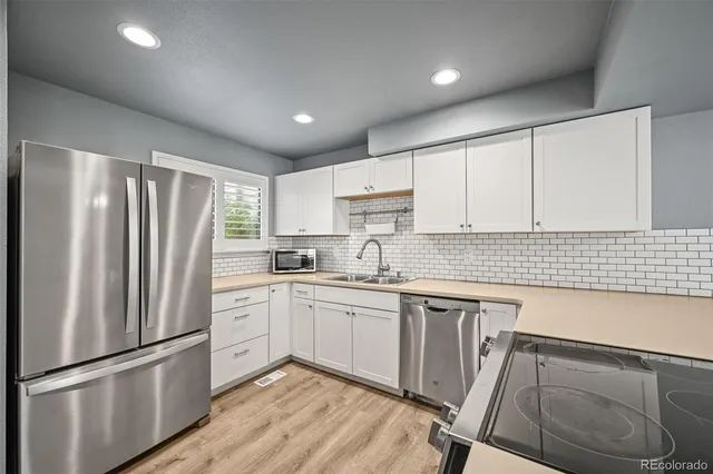 a kitchen with granite countertop a refrigerator and a sink