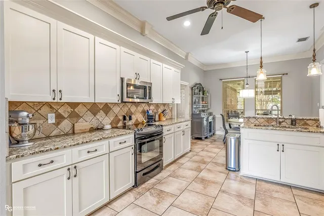 a kitchen with granite countertop white cabinets and white appliances
