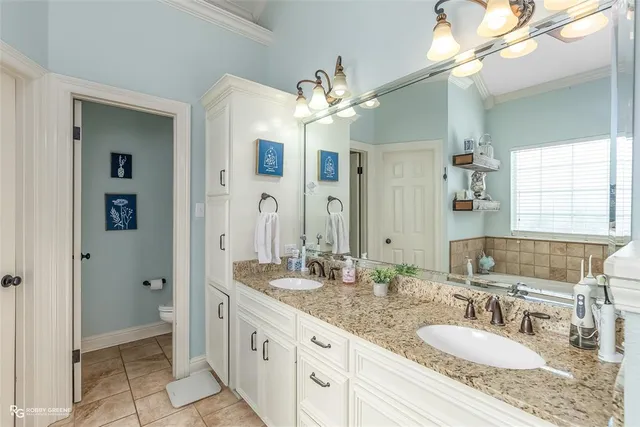 a bathroom with a granite countertop double vanity sink mirror and a shower