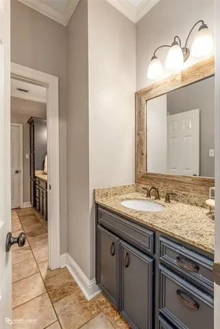 a en suite bathroom with a granite countertop sink and a mirror