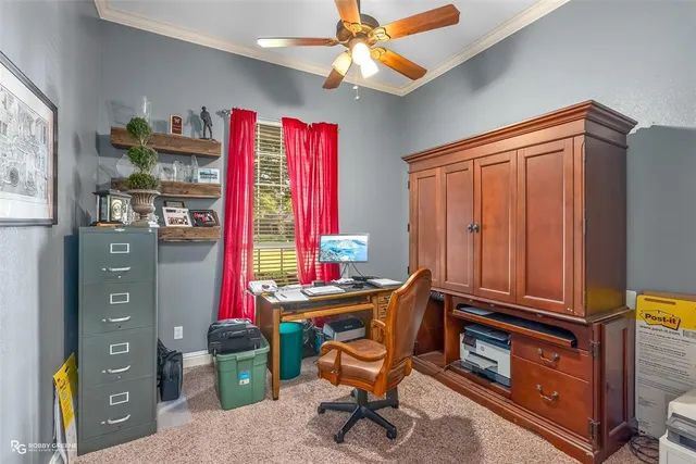 a view of a workspace with furniture and a window