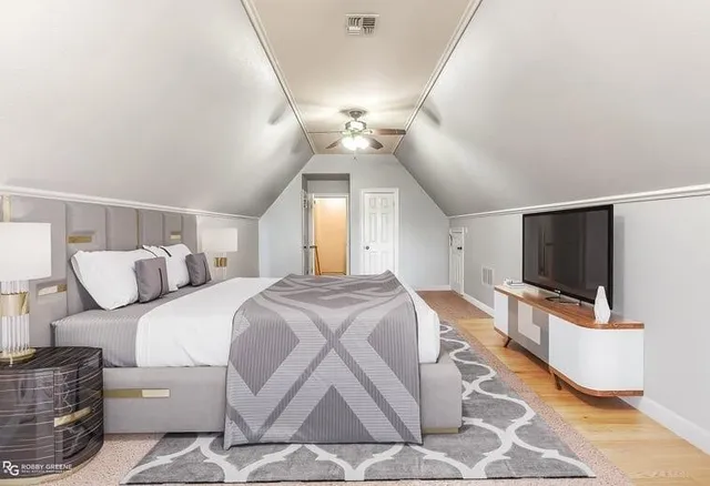 a spacious bedroom with a bed and a flat screen tv