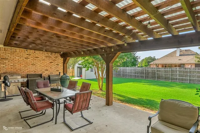 a view of a patio with a table chairs and a backyard
