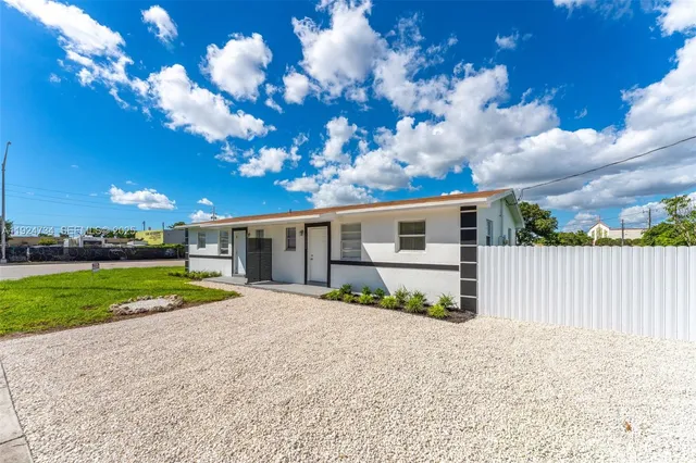a view of a house with a yard and large tree