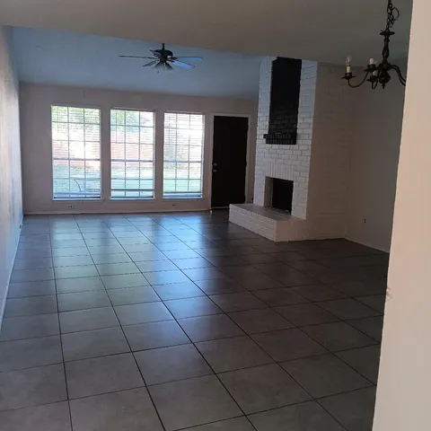 en empty room with windows and fireplace