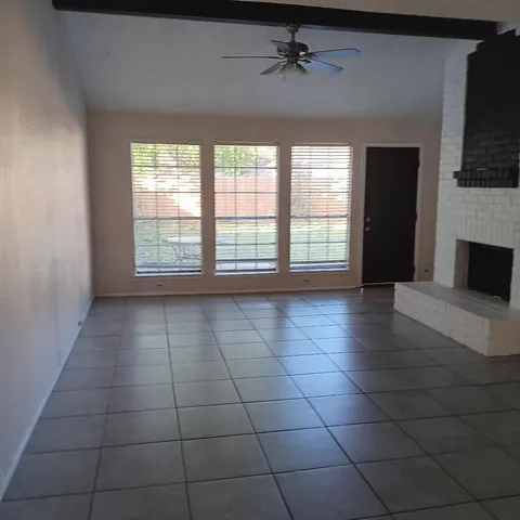 a view of an empty room with a fireplace and a window