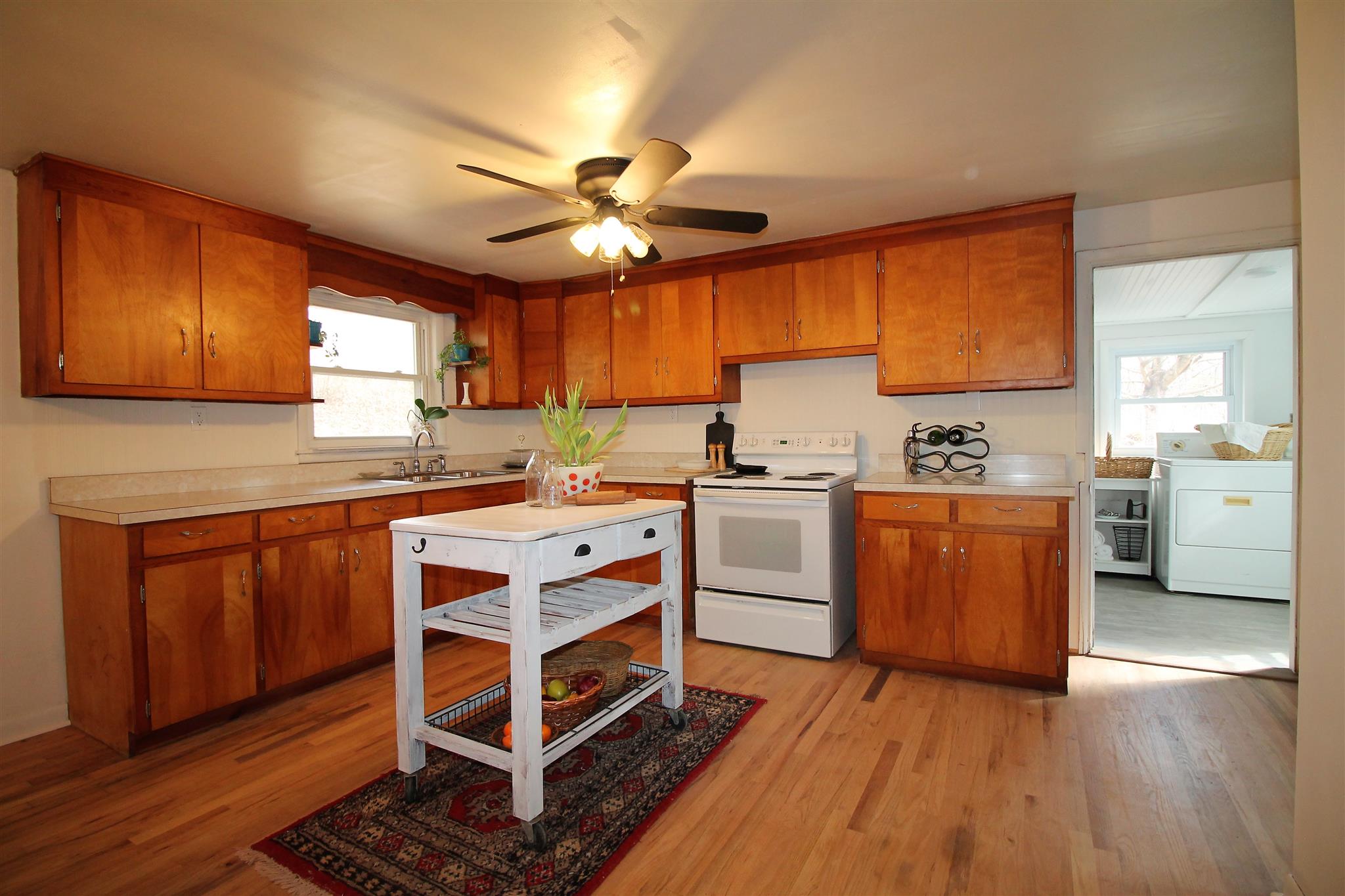 7205 Sleepy Hollow Road Fairview, TN 37062 - Photo 7 of 26 a kitchen with wooden floors and white cabinets