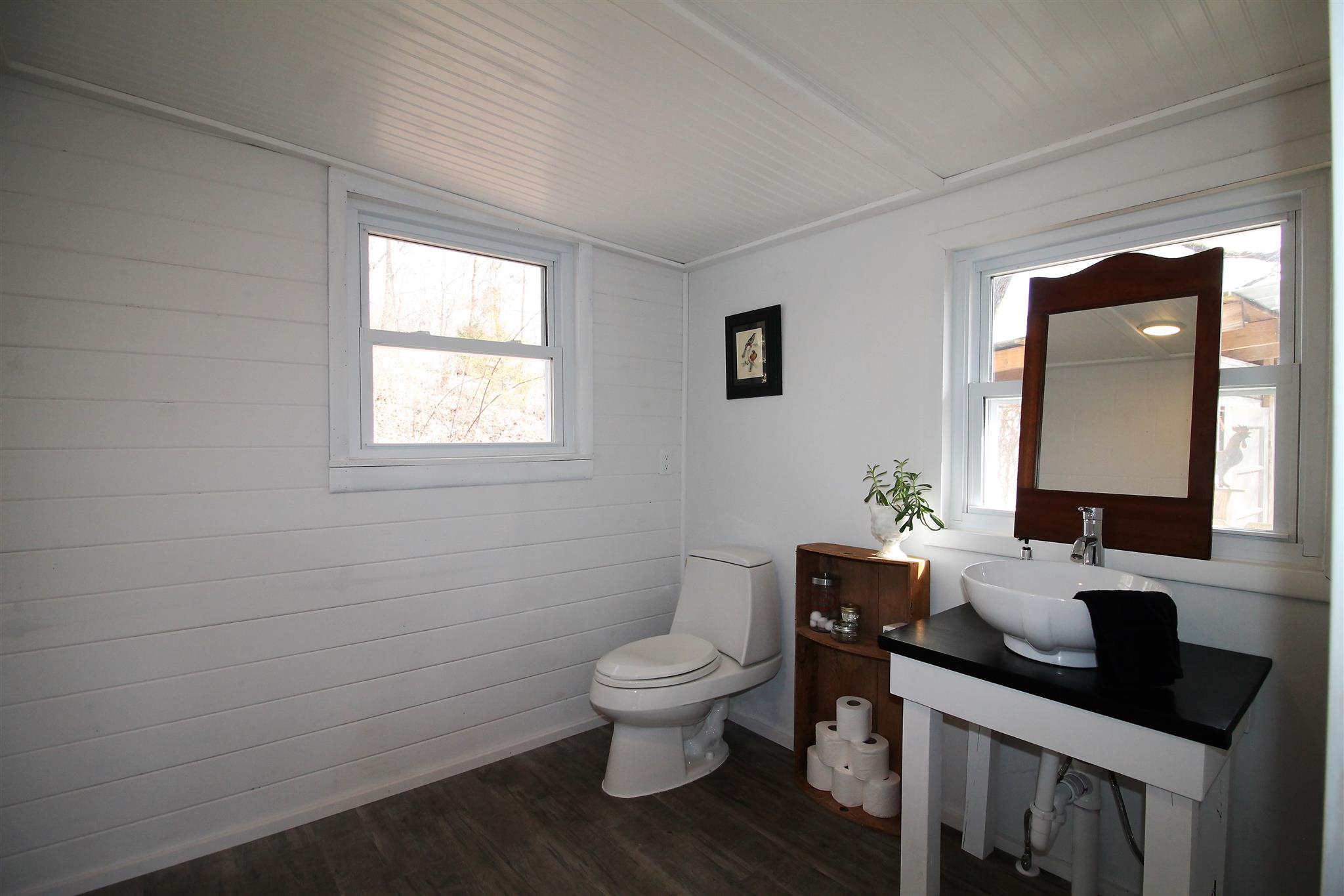 7205 Sleepy Hollow Road Fairview, TN 37062 - Photo 10 of 26 a bathroom with a granite countertop toilet a sink a mirror and a window