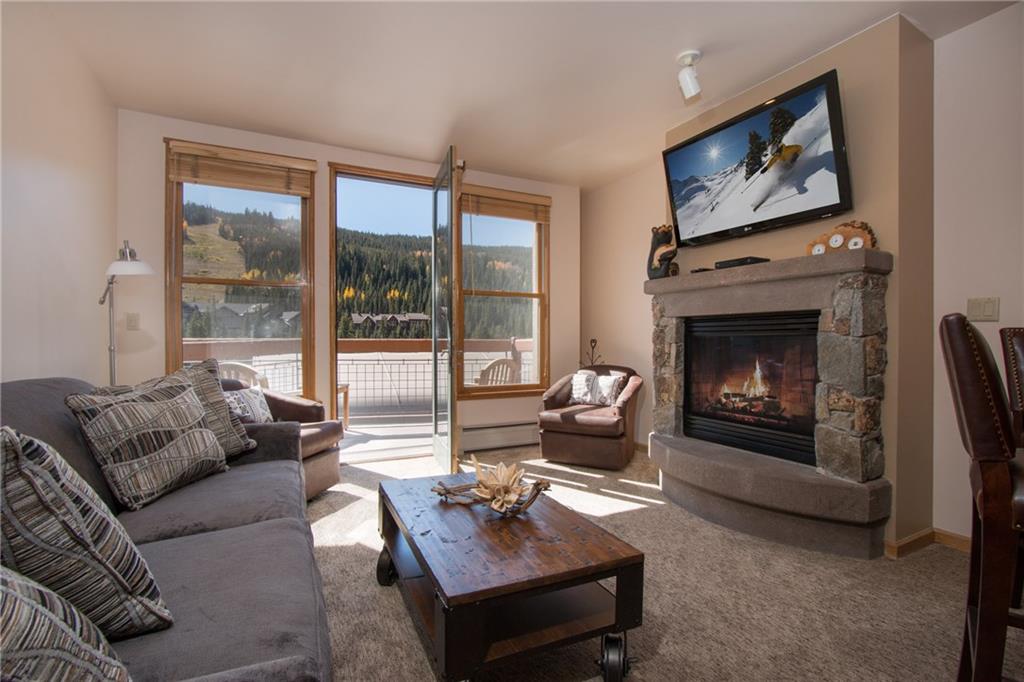 129 River Run Road, Unit 8061 Keystone, CO 80435 - Photo 3 of 19 a living room with furniture a floor to ceiling window and a fireplace