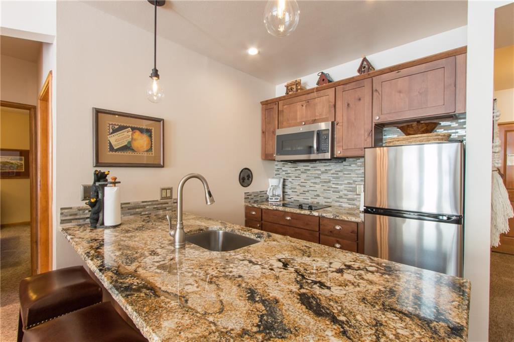 129 River Run Road, Unit 8061 Keystone, CO 80435 - Photo 5 of 19 a kitchen with stainless steel appliances granite countertop a sink refrigerator and microwave