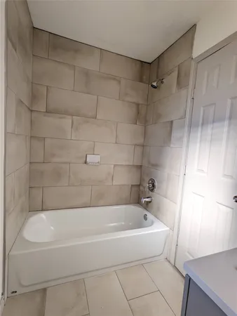 a white bath tub sitting next to a shower