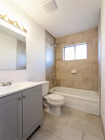 a bathroom with a toilet a sink a mirror a bathtub and shower
