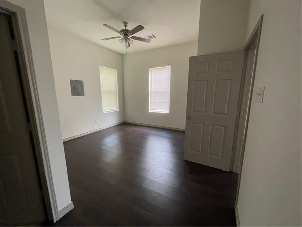 an empty room with wooden floor and window
