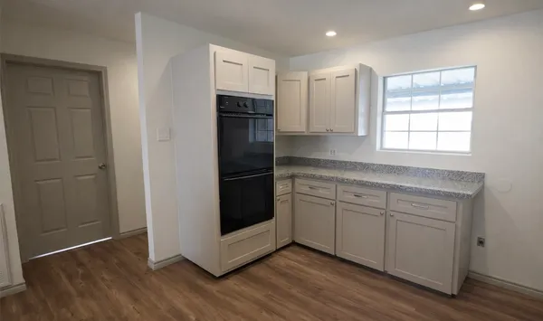 a kitchen with a refrigerator and white cabinets
