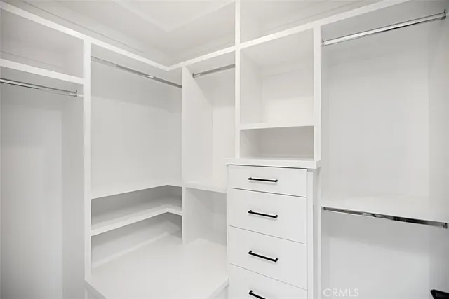 a view of walk in closet with empty racks