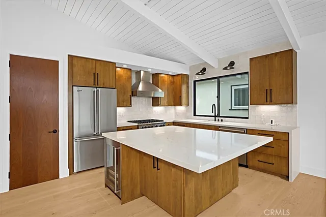 a kitchen with stainless steel appliances granite countertop a sink a refrigerator and a stove top oven