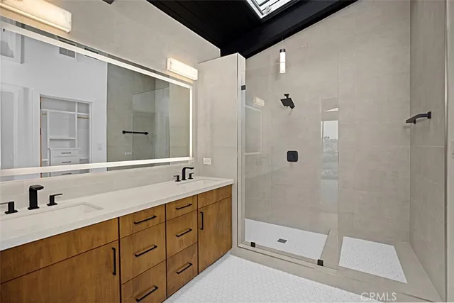 a bathroom with a double vanity sink toilet and shower