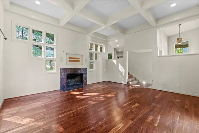 a view of empty room with wooden floor and fireplace
