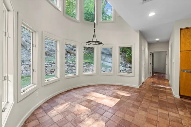a view of hallway with windows and chandelier