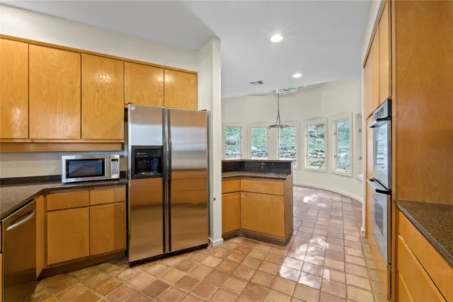 a kitchen with stainless steel appliances granite countertop a refrigerator and a stove top oven