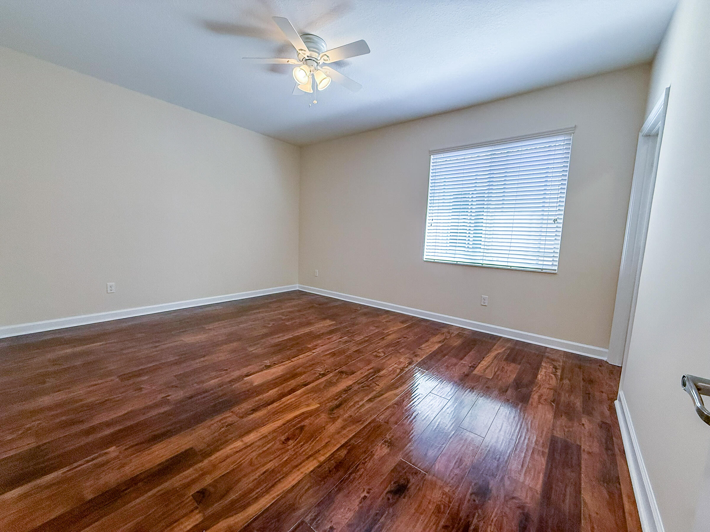 122 Northwest Gardner Street Boca Raton, FL 33432 - Photo 15 of 34 a view of an empty room with wooden floor and a window