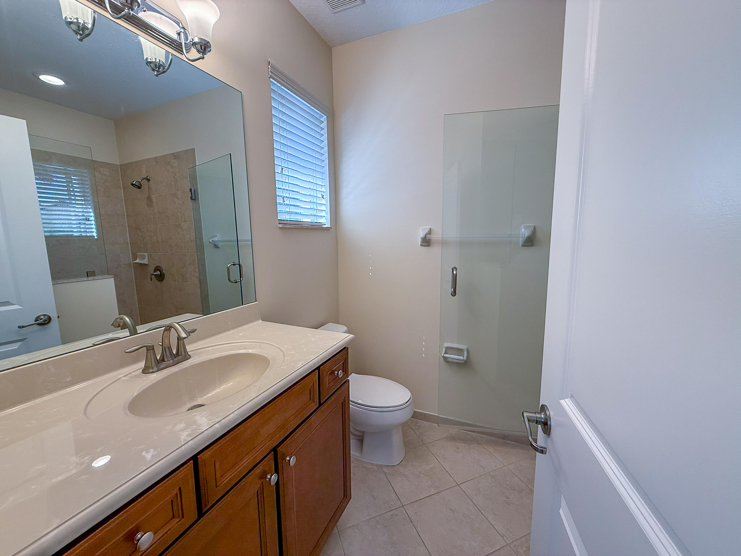 122 Northwest Gardner Street Boca Raton, FL 33432 - Photo 24 of 34 a bathroom with a sink a toilet a shower and a mirror
