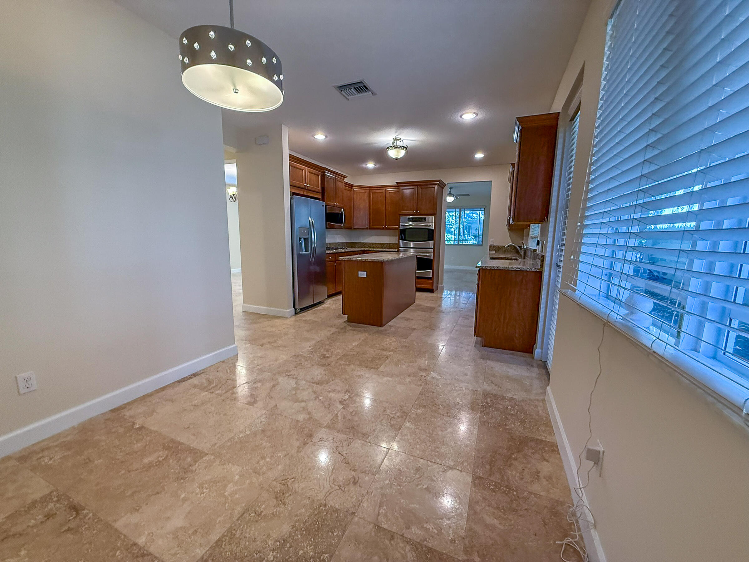 122 Northwest Gardner Street Boca Raton, FL 33432 - Photo 10 of 34 a kitchen with refrigerator and chairs