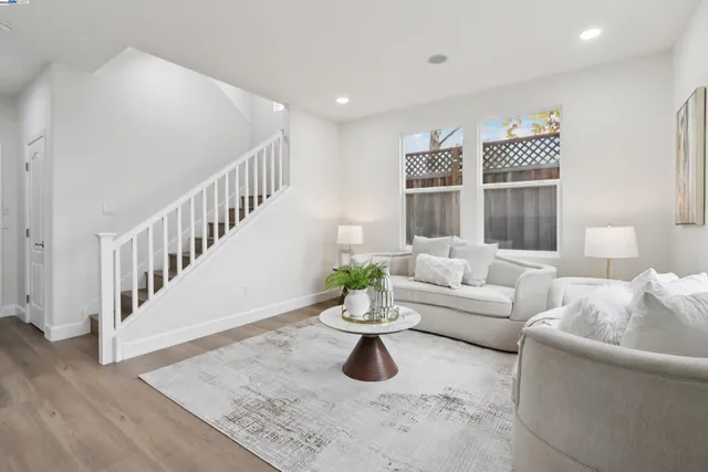a living room with couches and white couches with wooden floor