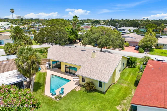 an aerial view of residential houses with outdoor space and trees