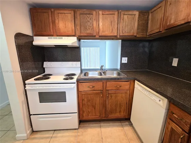 a kitchen with granite countertop cabinets stainless steel appliances and a sink