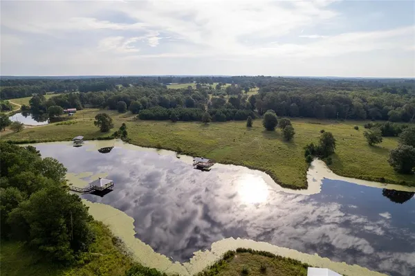 an aerial view of a house with a yard and lake view