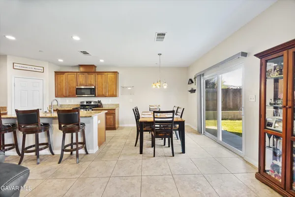 a kitchen with a dining table chairs and large appliances
