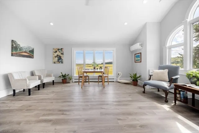 a living room with furniture a fireplace and a large window