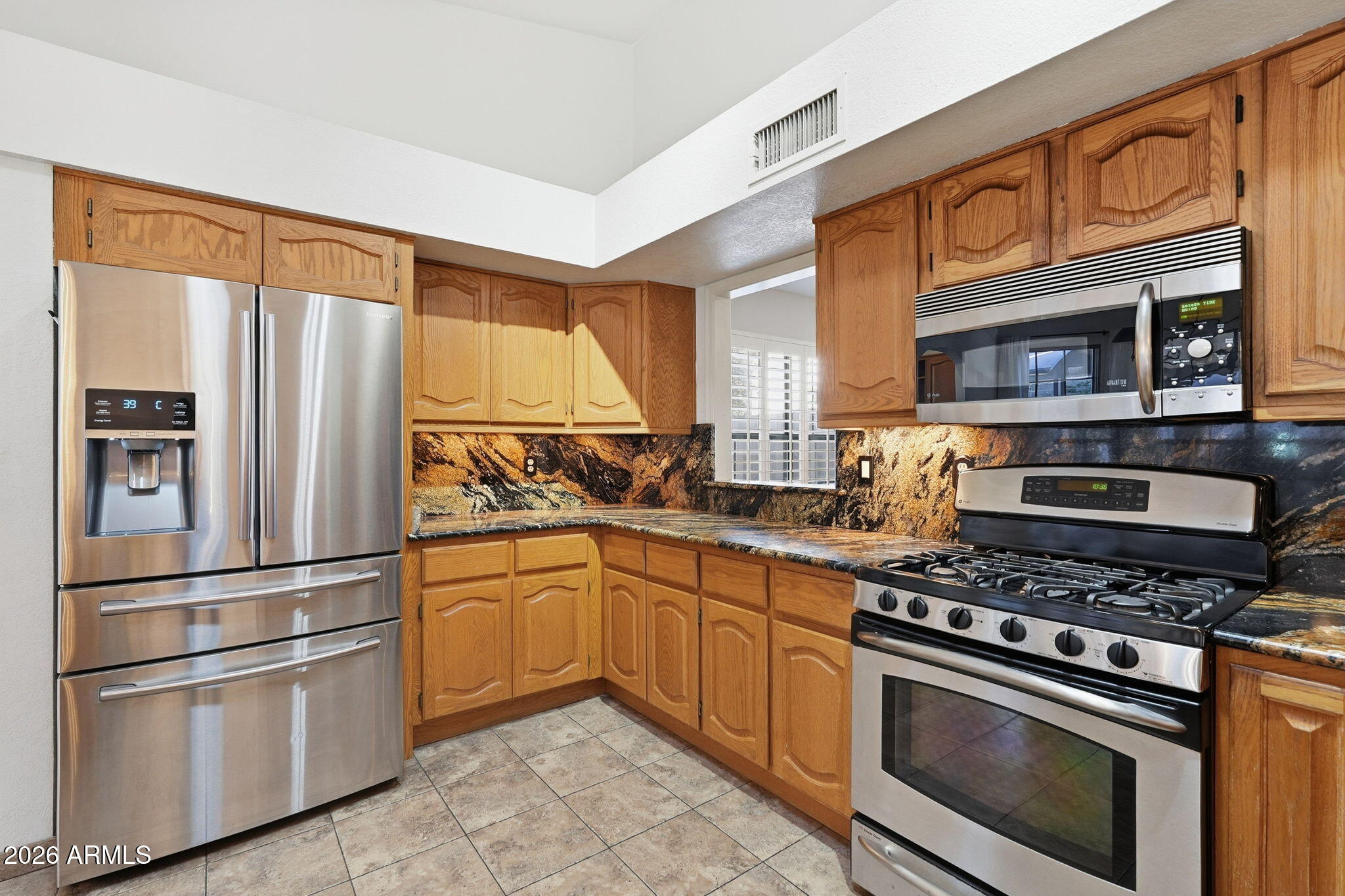 17002 South 34th Place Phoenix, AZ 85048 - Photo 4 of 27 a kitchen with stainless steel appliances granite countertop a refrigerator stove and sink