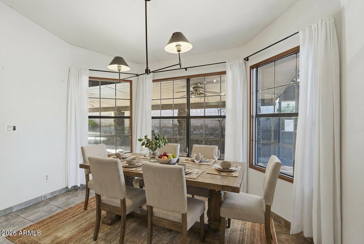 17002 South 34th Place Phoenix, AZ 85048 - Photo 8 of 27 a dining room with furniture a chandelier and wooden floor