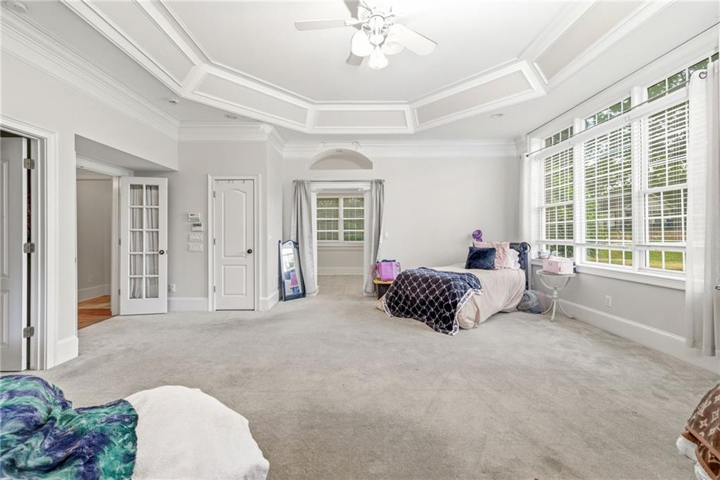 4337 Mountain View Road Oakwood, GA 30566 - Photo 24 of 84 a spacious bedroom with a bed and a chandelier