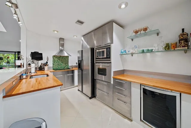 a kitchen with stainless steel appliances granite countertop a refrigerator sink and stove