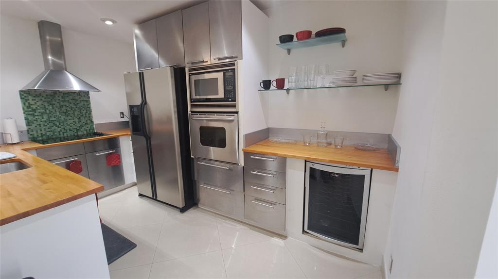 4519 Feivel Road, Unit 46 West Palm Beach, FL 33417 - Photo 12 of 56 a kitchen with white cabinets and stainless steel appliances