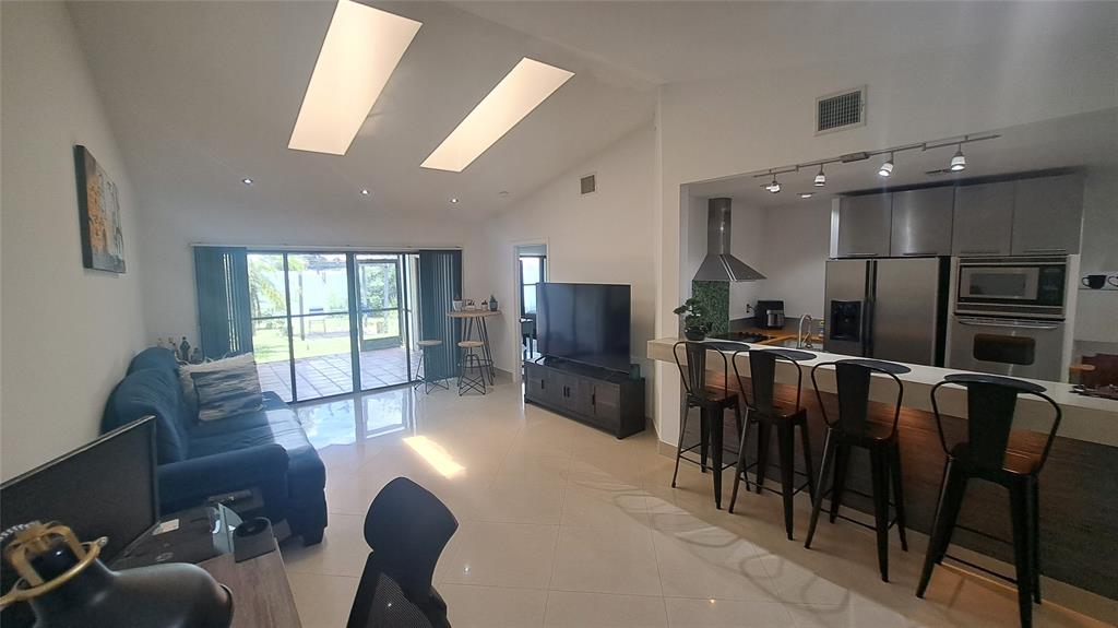 4519 Feivel Road, Unit 46 West Palm Beach, FL 33417 - Photo 16 of 56 a living room with stainless steel appliances furniture a rug kitchen view and a large window