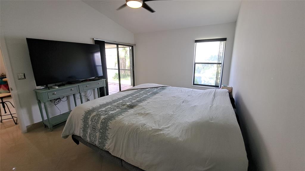 4519 Feivel Road, Unit 46 West Palm Beach, FL 33417 - Photo 21 of 56 a spacious bedroom with a bed and a flat screen tv