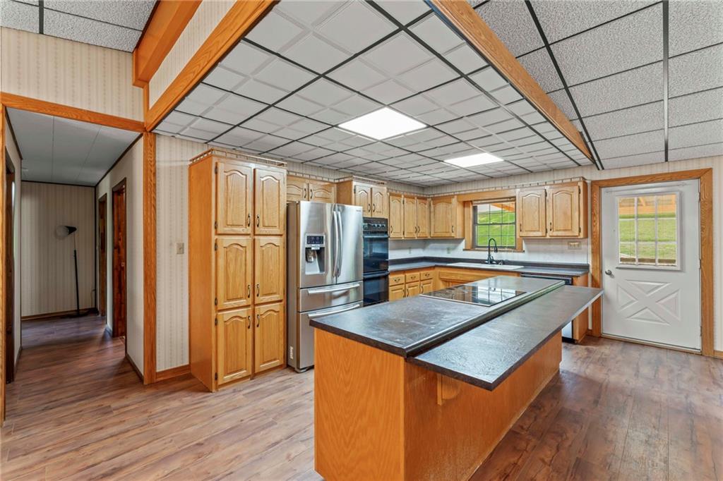 218 Gwynn Road Jefferson, PA 15344 - Photo 20 of 32 a kitchen with stainless steel appliances granite countertop a refrigerator a sink and wooden floors