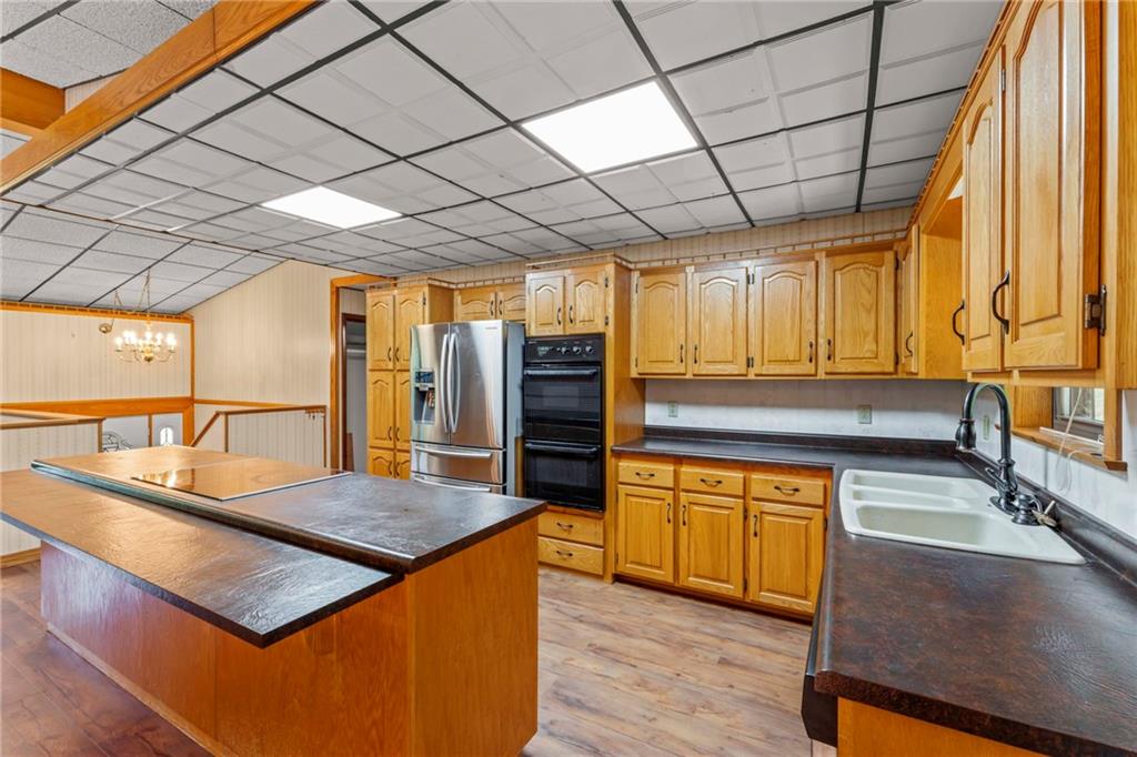 218 Gwynn Road Jefferson, PA 15344 - Photo 22 of 32 a kitchen with stainless steel appliances granite countertop a sink a stove counter space and wooden floor