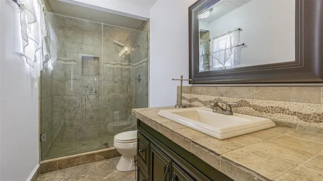 a bathroom with a sink a toilet and shower